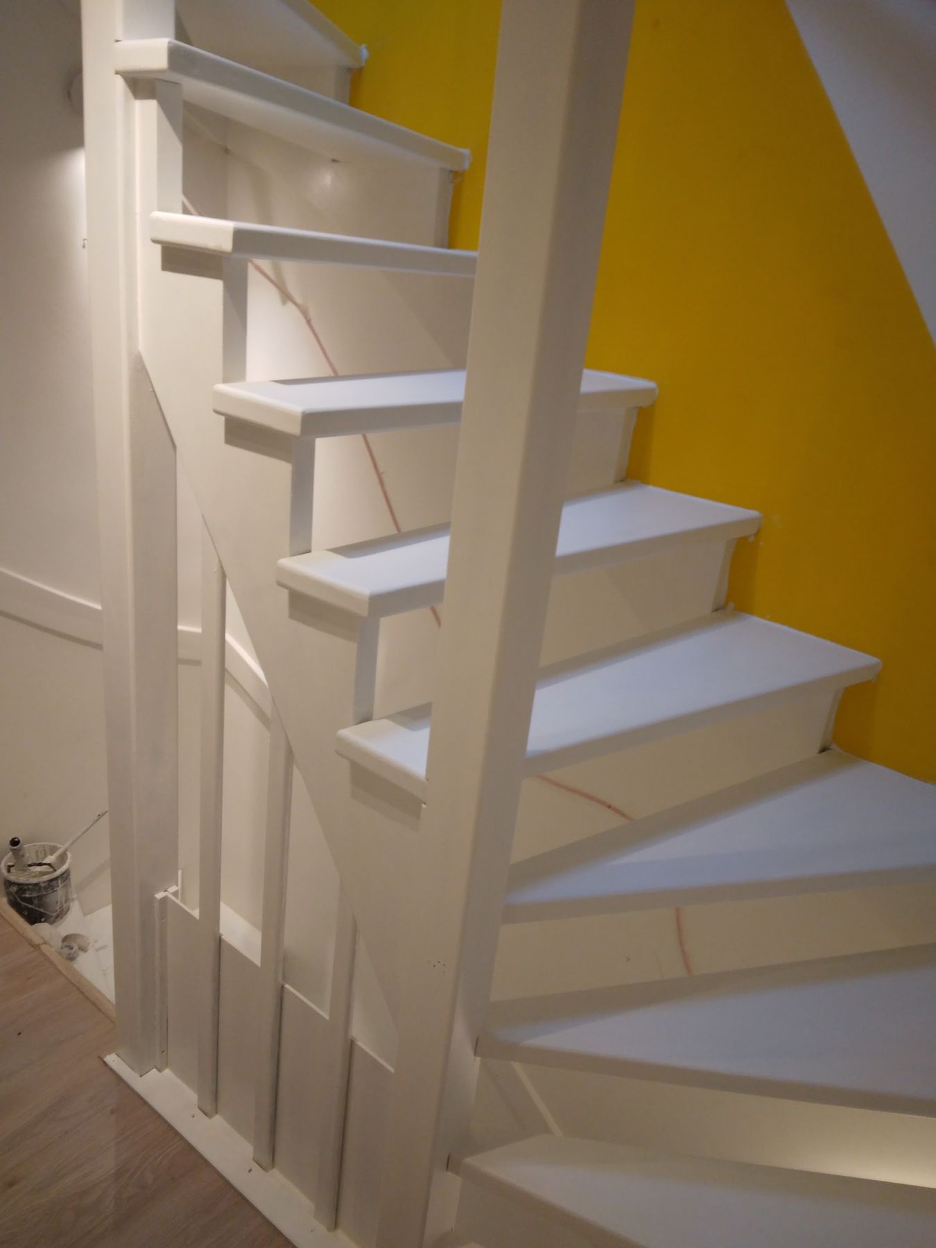 Open trap wit geschilderd tegen een gele wand